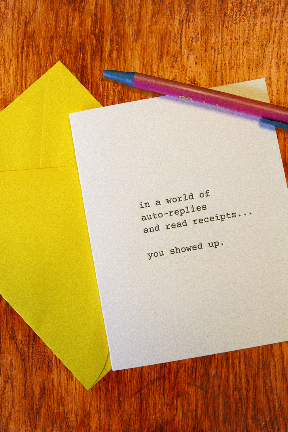 A white greeting card with black typewriter-style text reading 'in a world of auto-replies and read receipts.