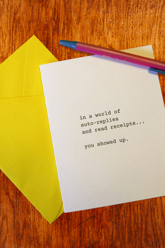 A white greeting card with black typewriter-style text reading 'in a world of auto-replies and read receipts.